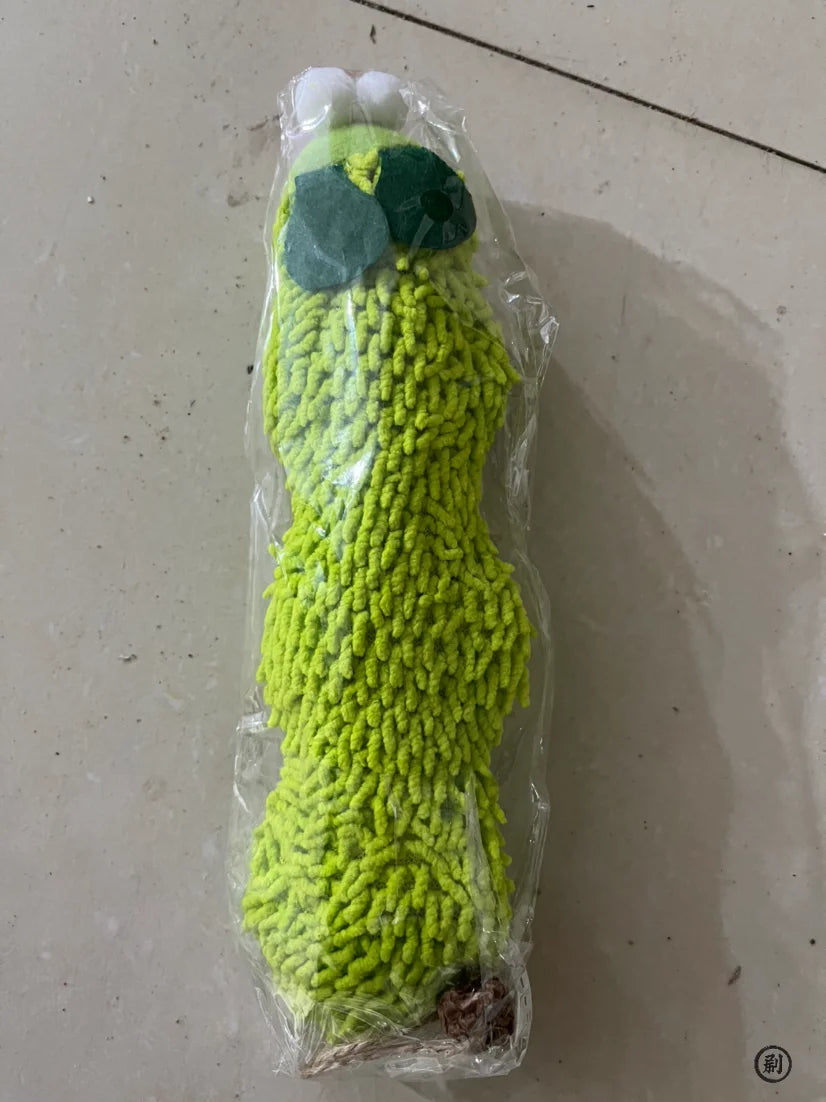 Green textured object wrapped in clear plastic on a light gray surface