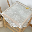 Lace tablecloth on a wooden table with a small cake and butterfly decoration.