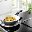 Stainless steel frying pan with food on a stovetop