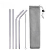 Set of metal straws with cleaning brush and mesh pouch on a white background