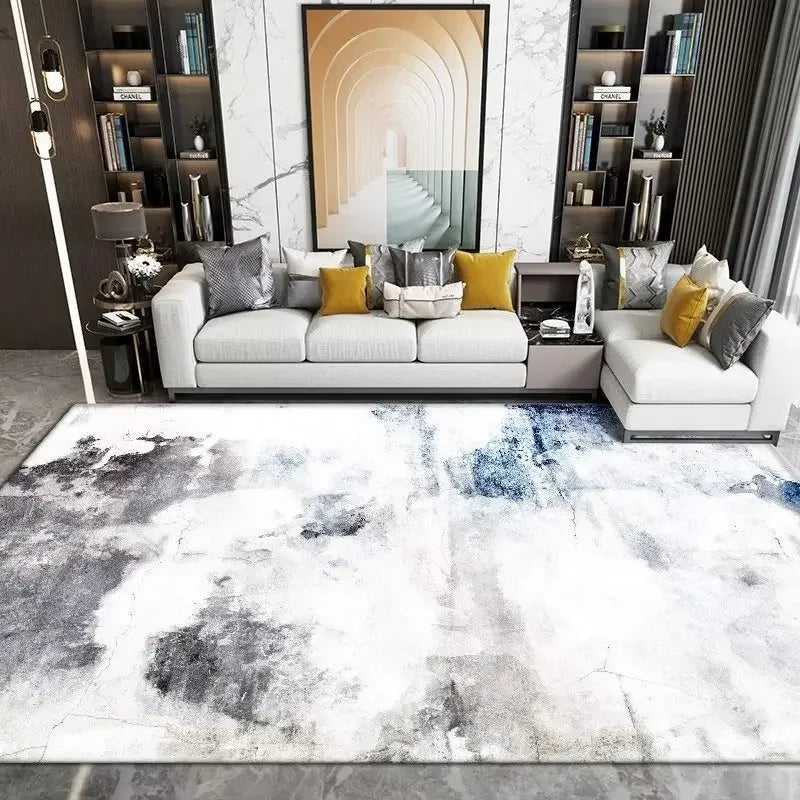 Modern living room with a gray sofa, colorful pillows, and an abstract patterned rug.