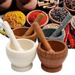 Mortars and pestles with a variety of spices in the background
