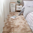 Beige carpet in a bedroom with a bed and nightstand.