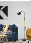 Modern living room with a blue sofa, yellow chair, and standing lamp.