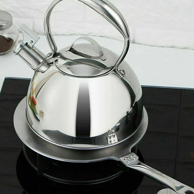 Stainless steel kettle on a stove with a white tiled wall in the background