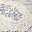Decorative white plate with blue floral design on a marble surface