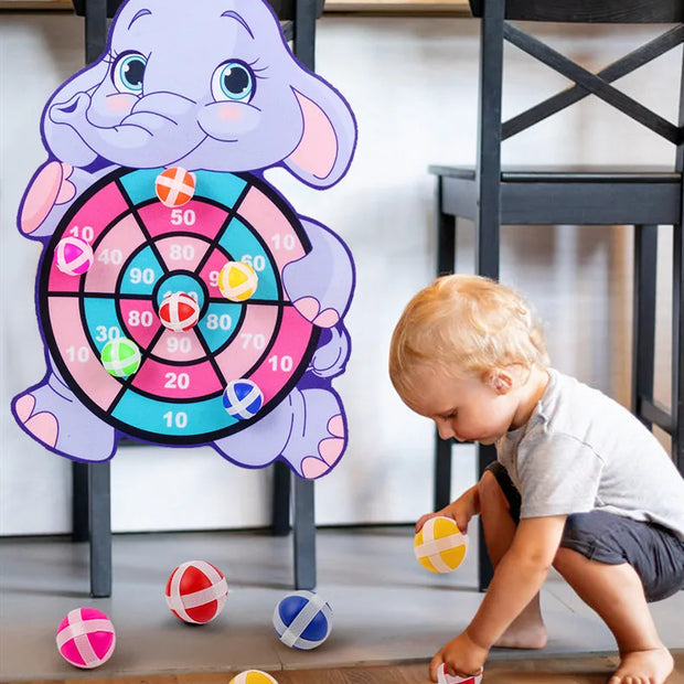 Child playing with a dartboard shaped like an elephant in a home setting