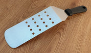 Paddle with blue surface and brown holes on a wooden floor