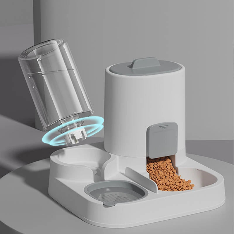Pet feeding and water station with transparent water container, white food container, and gray bowl on a gray background.