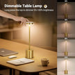Gold dimmable table lamp on a desk with brightness levels displayed.