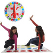 Two children playing Twister on a colorful mat with a large spinner in the background.