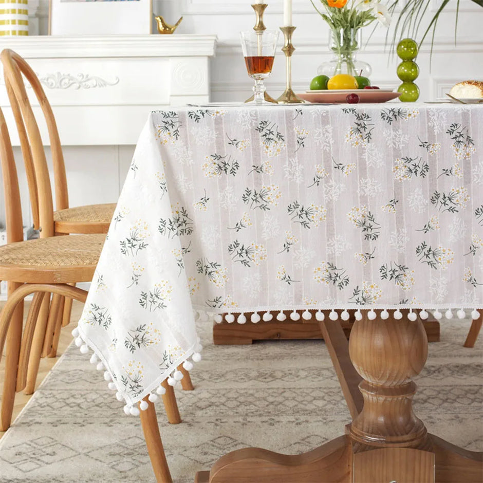 Dining table with a floral tablecloth and decorative items in a home setting
