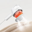 White handheld showerhead with red light emitting onto a beige surface