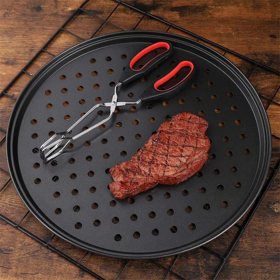 Steak on a perforated grill pan with tongs on a wooden surface