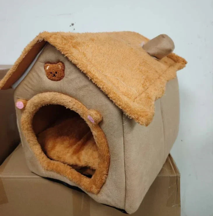 Pet house resembling a wooden cabin with a soft roof and entrance.