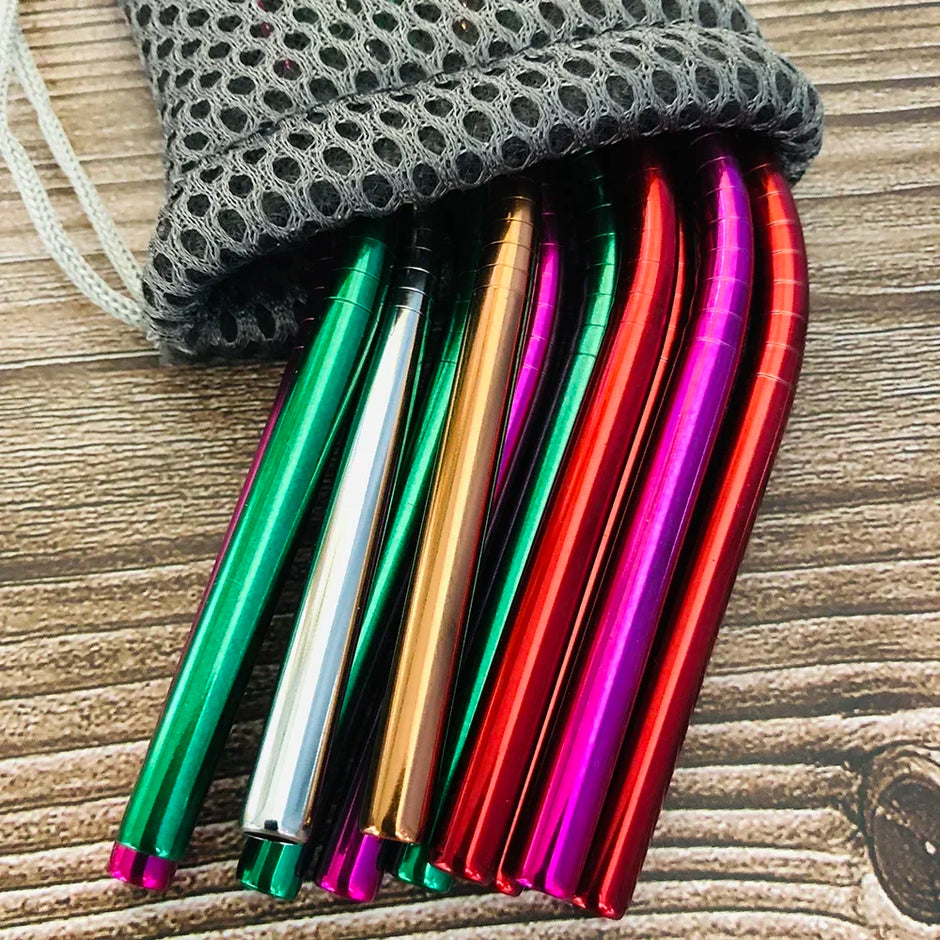 Colorful metal straws with a gray mesh bag on a wooden surface