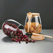 Glass jars with wooden spoons and dried herbs on a gray surface