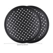 Two black perforated pizza trays with white dots on a white background
