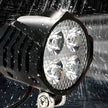 Waterproof LED light projector with water droplets on a dark background