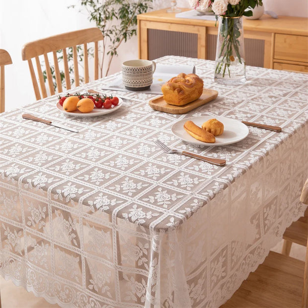 Dining table with a patterned tablecloth, plates of food, and cutlery.