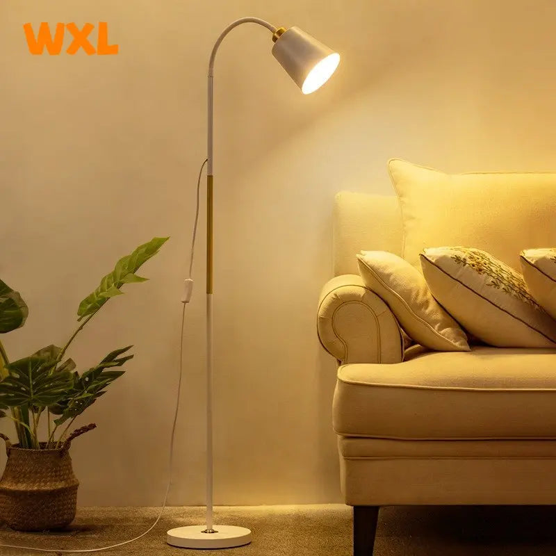Floor lamp next to a beige sofa with pillows in a cozy living room setting.
