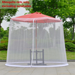 Mosquito net around a red outdoor umbrella with greenery in the background
