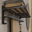 Black towel rack with folded towels on a bathroom wall