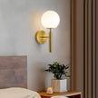 Modern wall sconce with a spherical light fixture on a neutral wall.