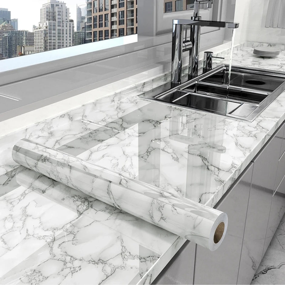 Roll of marble-patterned contact paper on a kitchen counter with a cityscape in the background