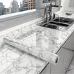 Roll of marble-patterned contact paper on a kitchen counter with a cityscape in the background
