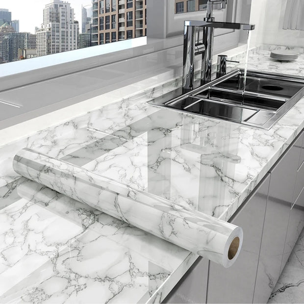 Roll of marble-patterned contact paper on a kitchen counter with a cityscape in the background