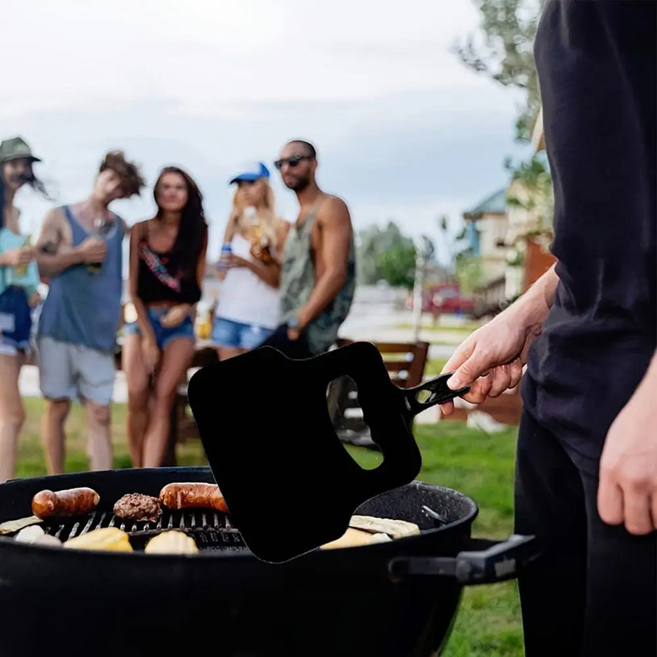 Person grilling outdoors with friends in the background