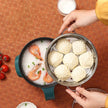 Steaming basket with buns and a bowl of rice with shrimp on a textured surface.