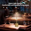 Gold table lamp on a table with wine glasses, creating a warm and romantic atmosphere.