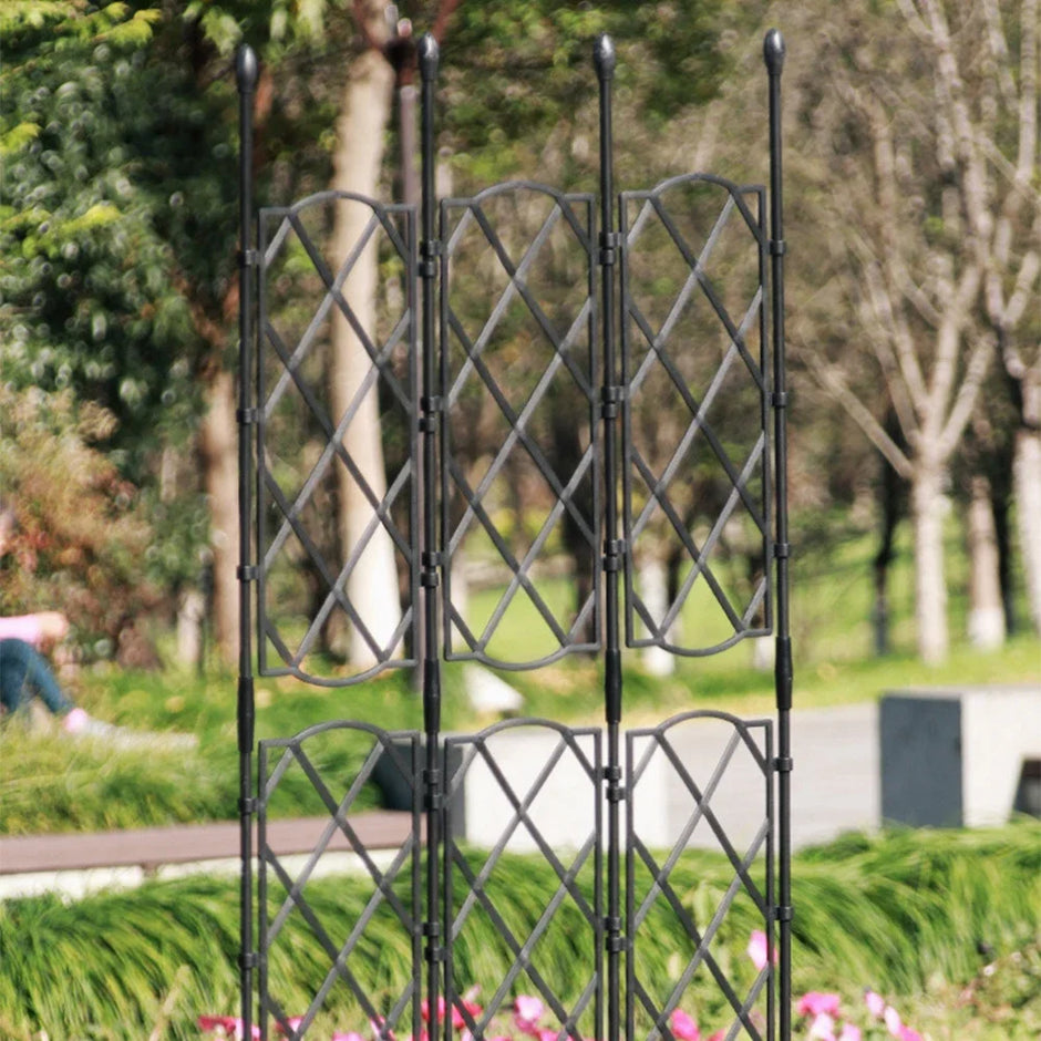 Black metal trellis in a garden setting with blurred background