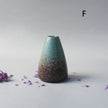 Tapered ceramic vase with a textured surface on a light gray background