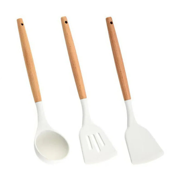 Three white kitchen utensils with wooden handles on a white background