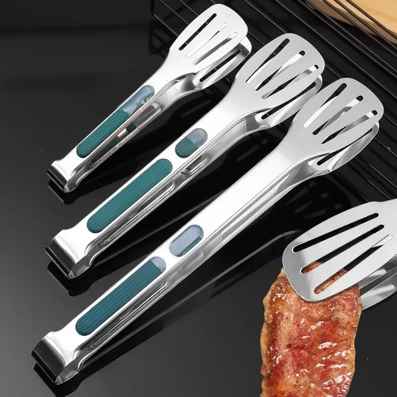 Set of four metal spatulas with green handles on a grill background