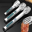 Set of four metal spatulas with green handles on a grill background