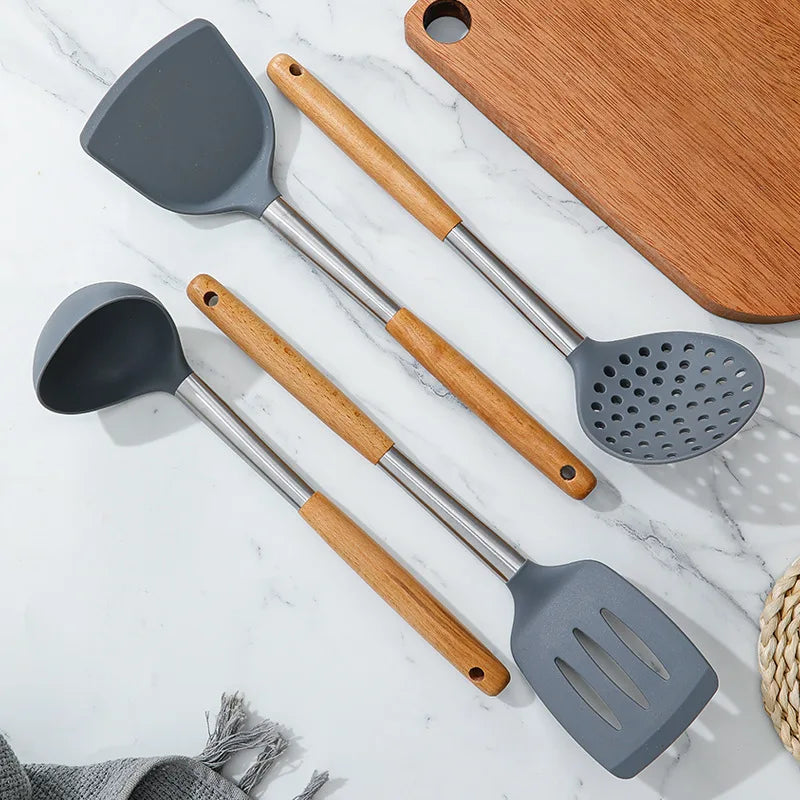 Set of kitchen utensils with wooden handles on a marble surface