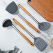 Set of kitchen utensils with wooden handles on a marble surface