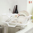 White dish rack with dishes on a kitchen counter next to a sink