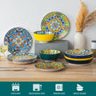 Colorful ceramic dinnerware set on a wooden surface with decorative elements.