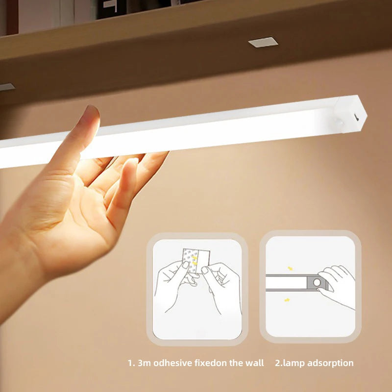 Hand holding a light fixture with adhesive pads on a beige background