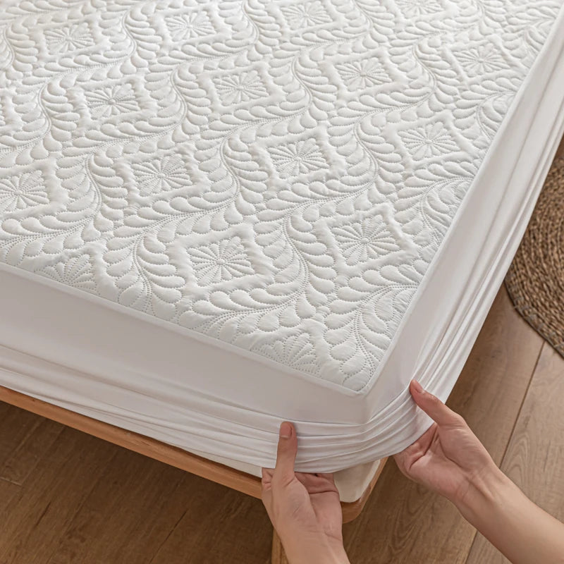 Person installing a white mattress protector on a bed