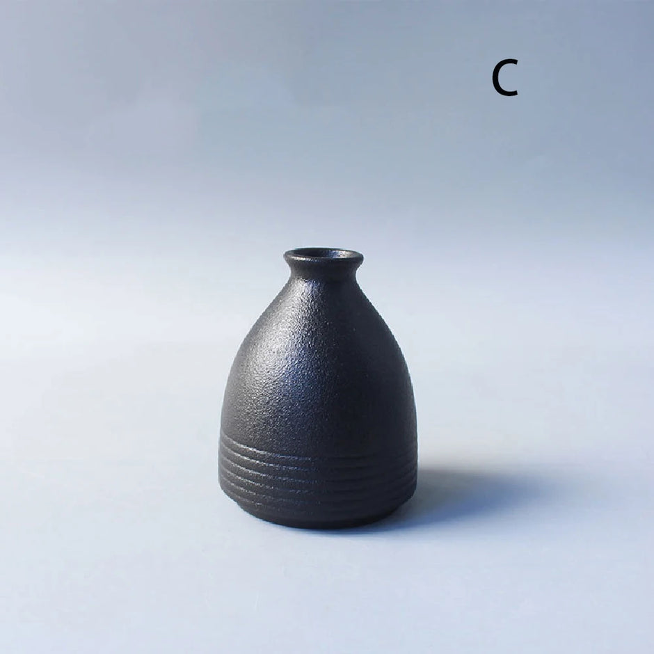 Black ceramic vase on a light gray background