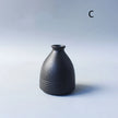 Black ceramic vase on a light gray background