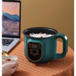Teal electric rice cooker with digital display on a wooden surface next to a laptop.