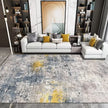 Modern living room with a gray and yellow patterned rug, white sofa, and decorative pillows.