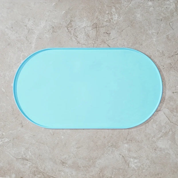 Light blue bath mat on a beige tiled floor